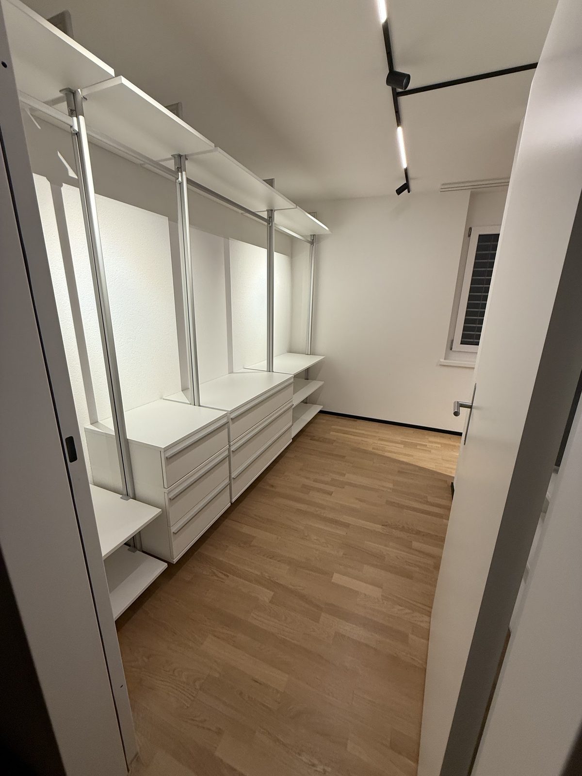 Ankleidezimmer mit Schranksystem, Blick durch die offene Tür